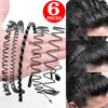 A hand displays six black metal hair bands coiled and laid out for sale.