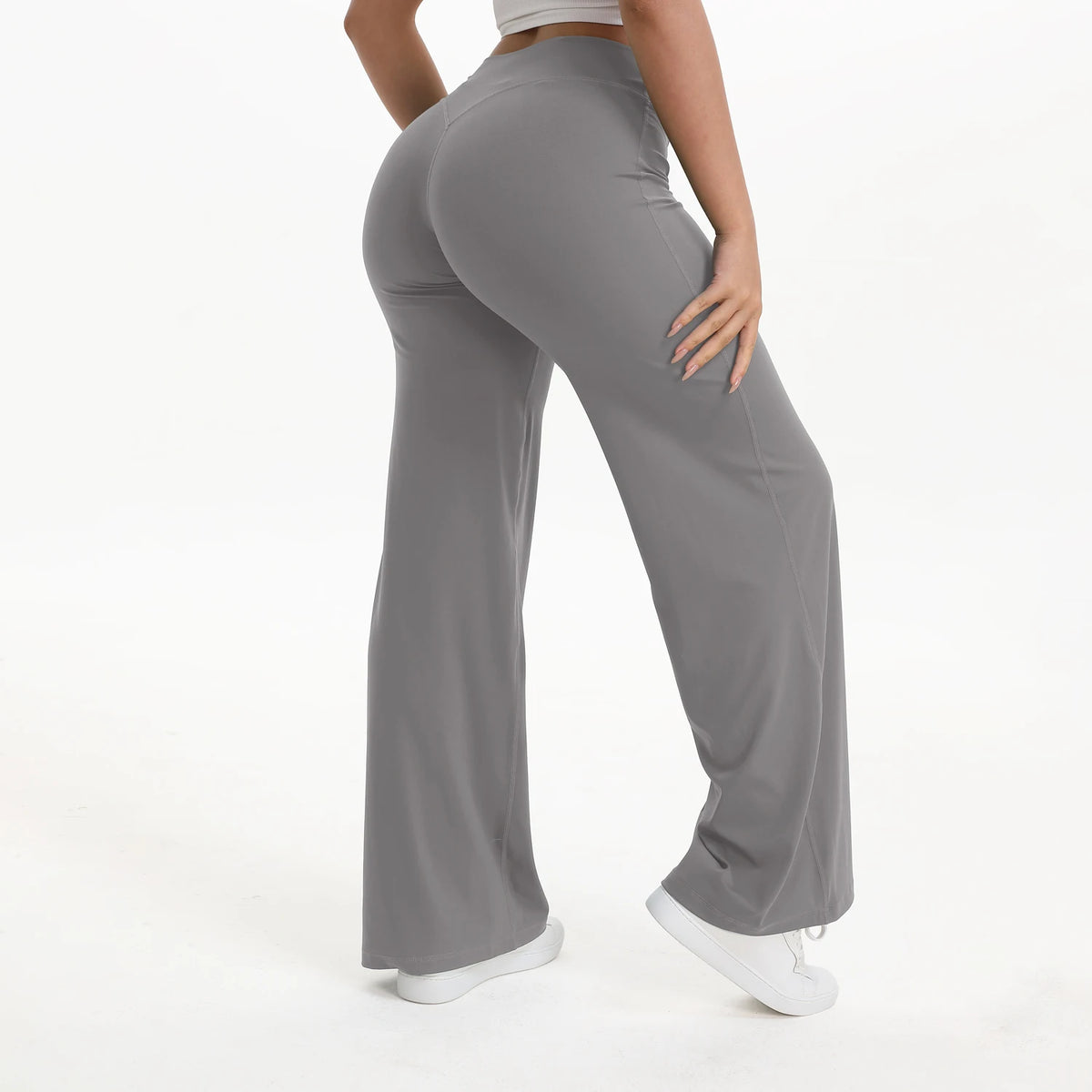 A person wearing gray NCLAGEN SoftMotion straight leg yoga pants standing and looking down.