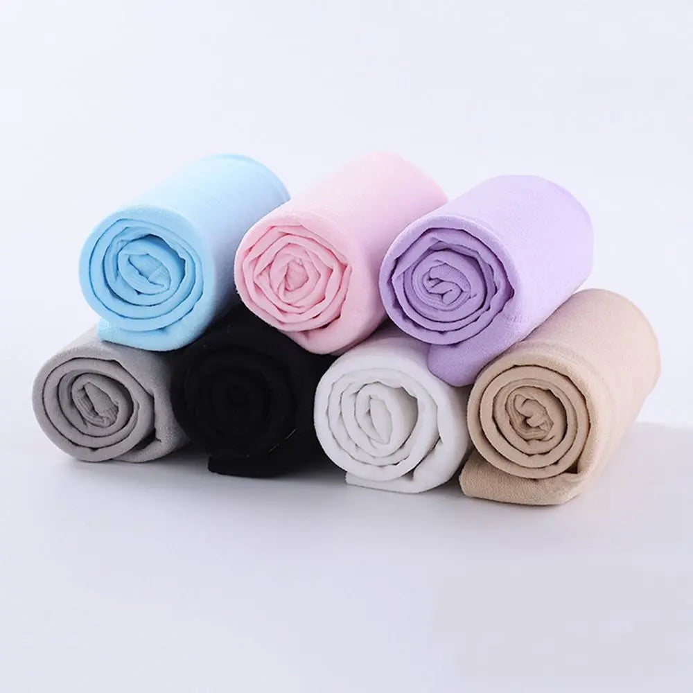 A collection of rolled all-weather arm sleeves in various pastel colors including blue, pink, lavender, and beige.
