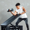 Muskulöser Mann hebt eine schwarze Hantel während eines Workouts auf einer Fitnessbank.
