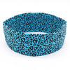 A teal and black leopard print women's sports headband worn on a white background.