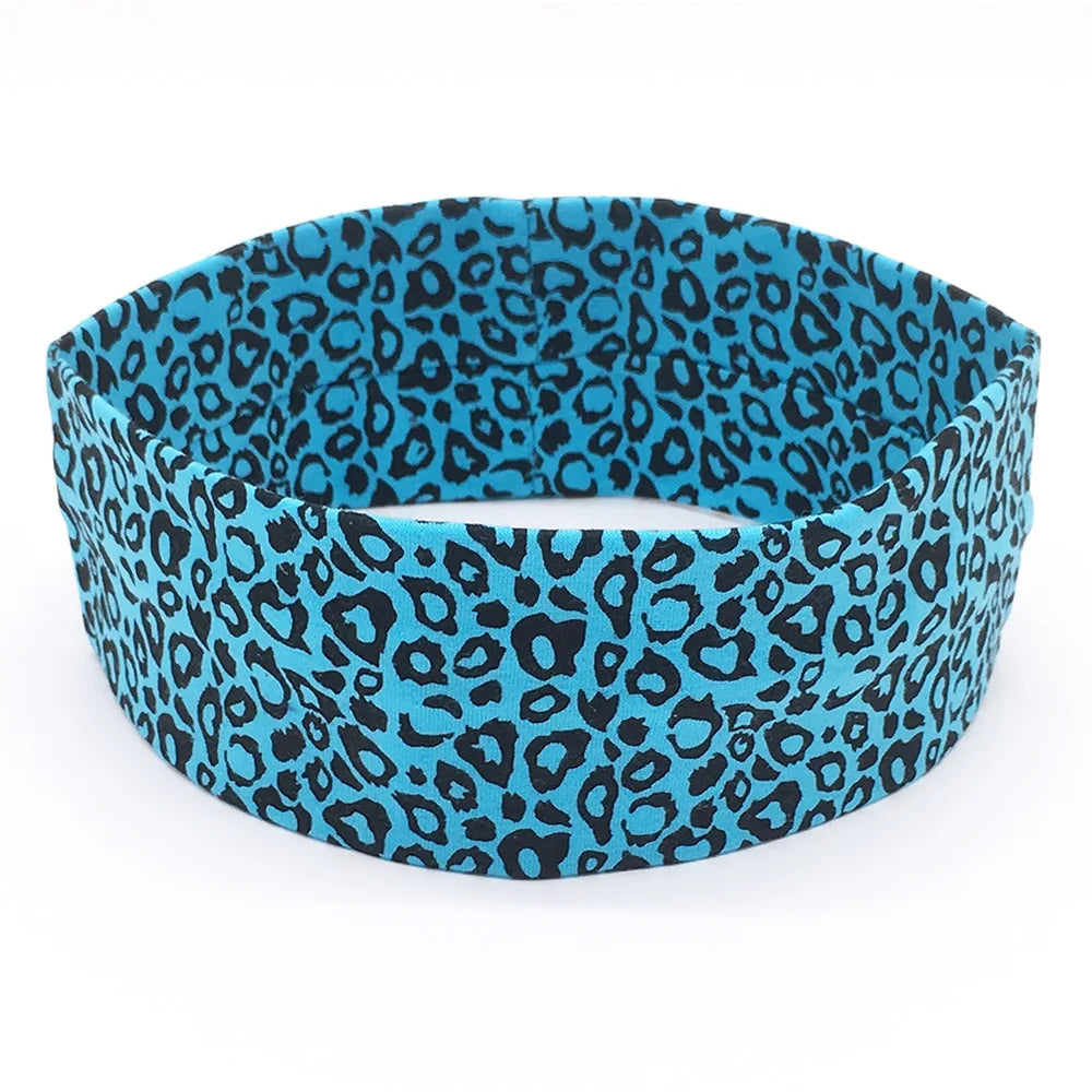 A teal and black leopard print women's sports headband worn on a white background.