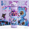 A purple cartoon character water bottle with a carrying strap set against a colorful background featuring cat characters.