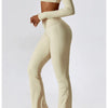 A woman models a beige performance tracksuit set consisting of a cropped long-sleeve top and matching high-waisted pants.