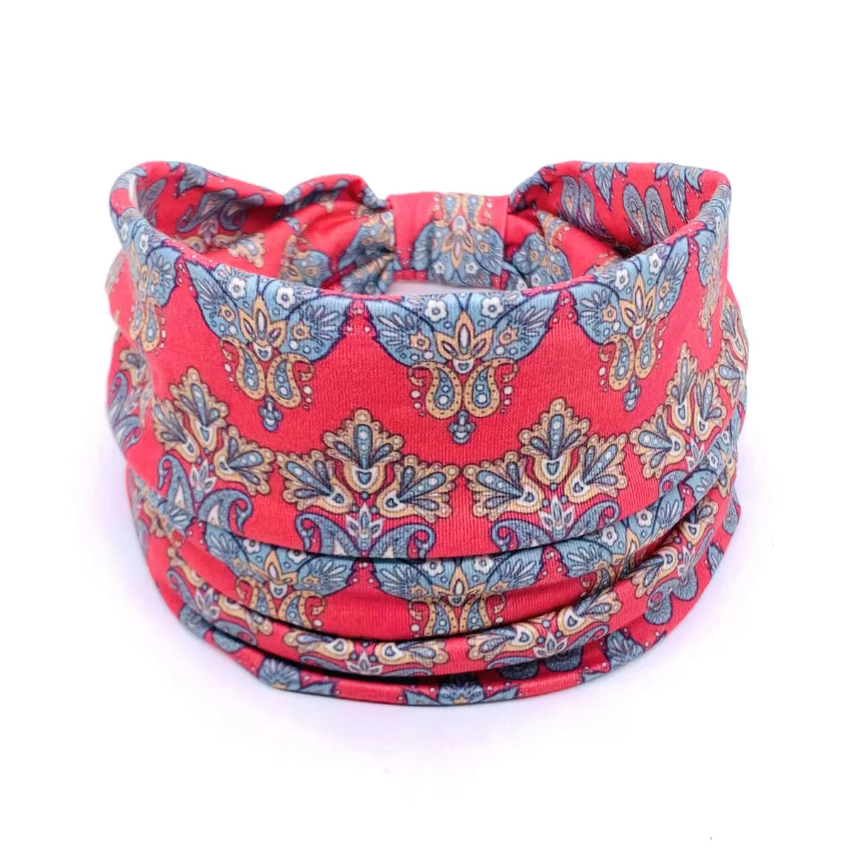 A red and blue patterned bohemian stretch cotton headband rolled into a coil.