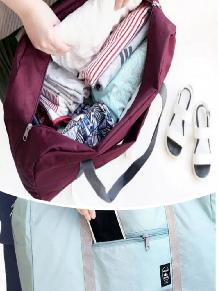 A maroon foldable travel duffel bag is shown being carried in a light blue fabric bag.
