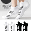 Une paire de chaussettes de sport blanches à coupe basse avec des rayures grises, montrées sur un pied et un gros plan du des