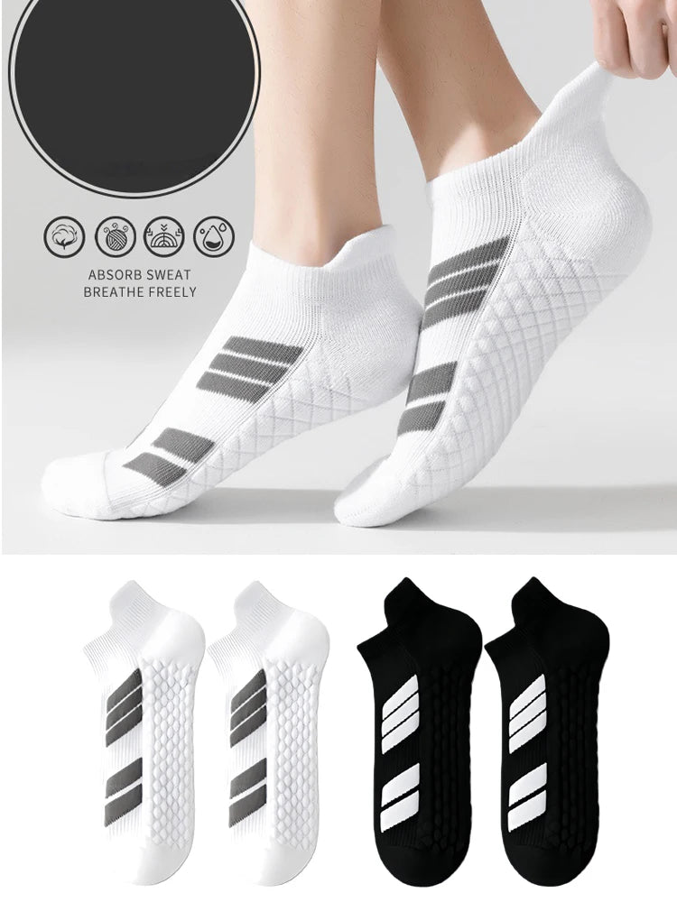 Une paire de chaussettes de sport blanches à coupe basse avec des rayures grises, montrées sur un pied et un gros plan du des