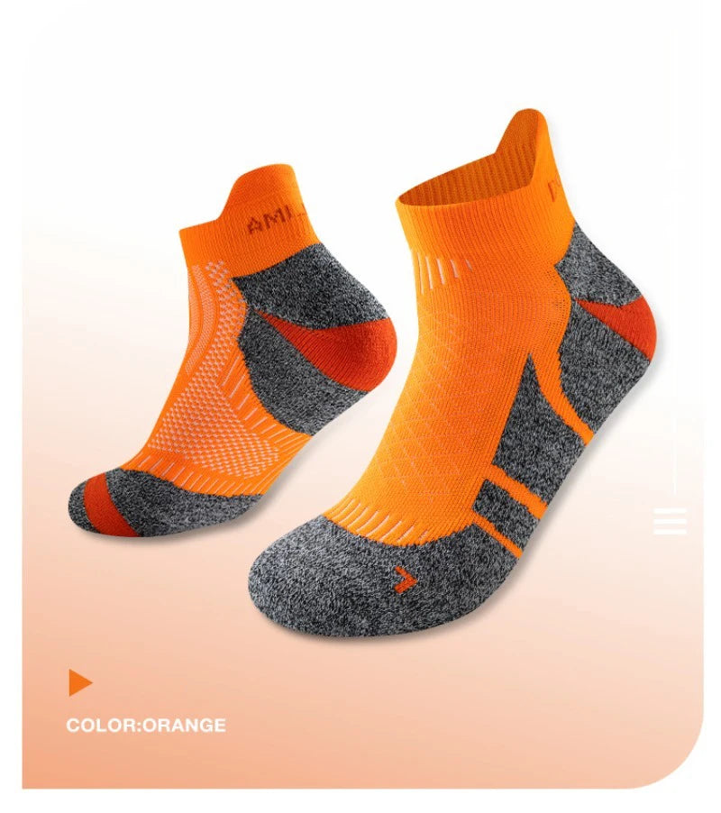 A pair of orange performance sports ankle socks with gray accents shown from the side.
