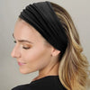 Une femme aux cheveux blonds porte un foulard en coton bohème noir sur la tête.