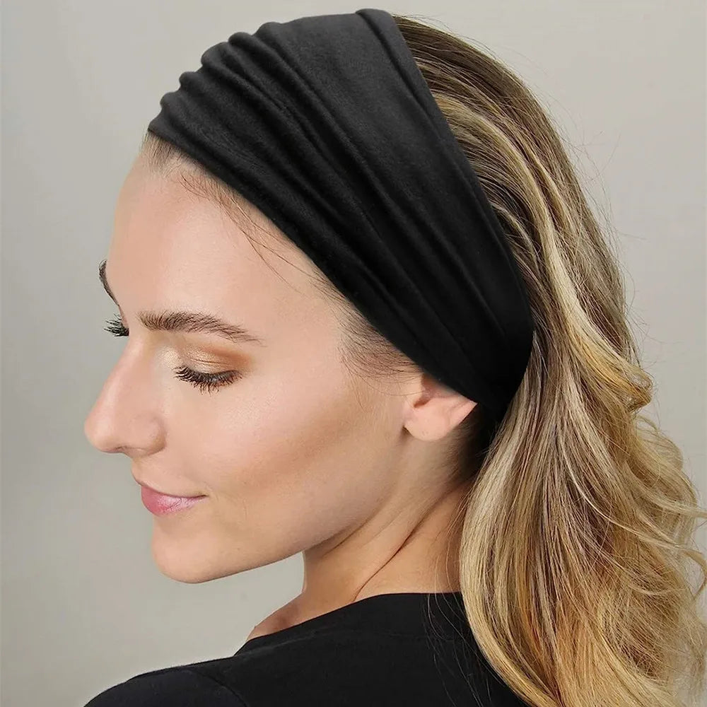Une femme aux cheveux blonds porte un foulard en coton bohème noir sur la tête.