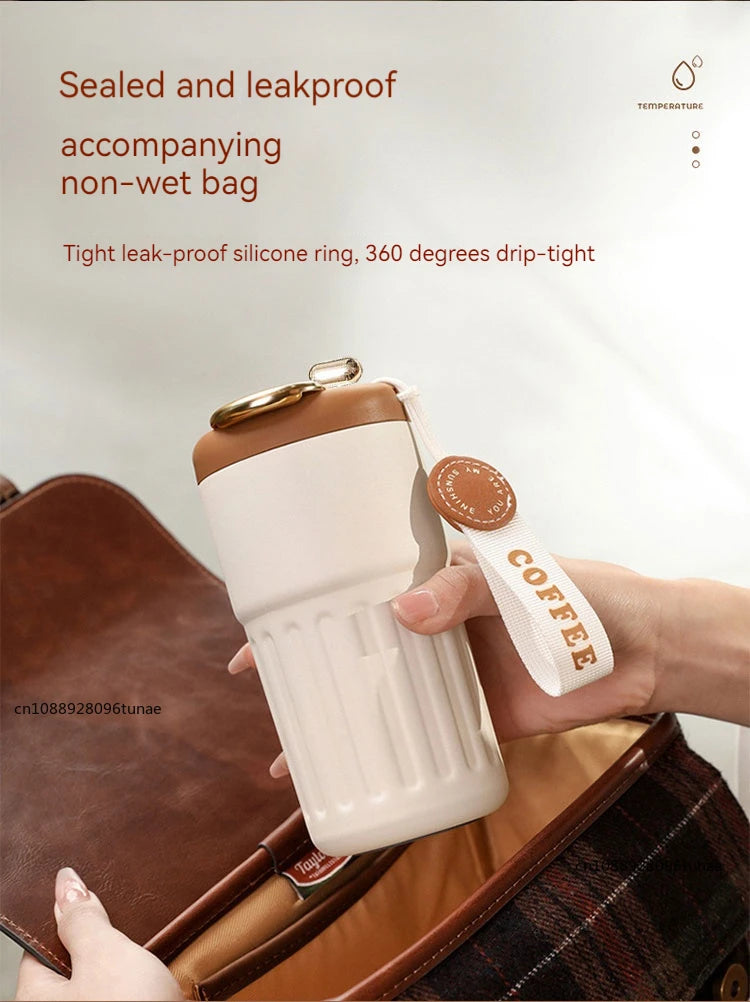 A white thermo mug with a brown lid is being held, demonstrating its sealed and leakproof design.