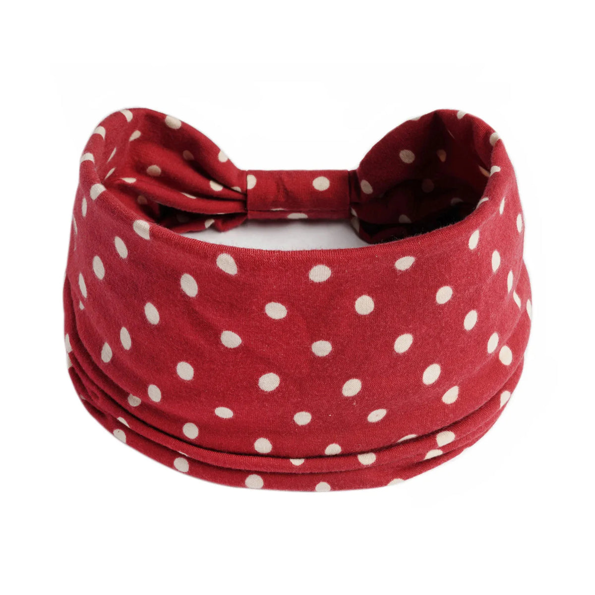 A red polka dot knotted headband worn around the head.
