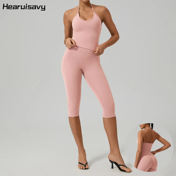 A woman models a pink two-pack women's yoga activewear set consisting of a tank top and leggings.
