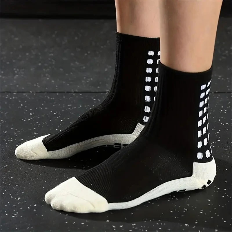 A pair of black and white non-slip silicone sports socks for football or basketball