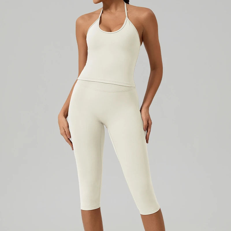 Eine Frau trägt ein cremefarbiges Yoga-Activewear-Set aus Tanktop und Leggings.