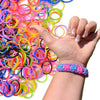 Una mano sostiene una gran pila de bandas elásticas de telar de colores para hacer pulseras.