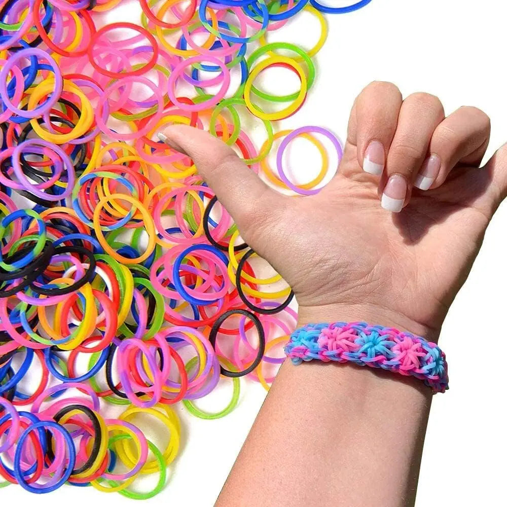 Una mano sostiene una gran pila de bandas elásticas de telar de colores para hacer pulseras.