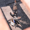 Stainless steel folding grappling hook with various tools resting on a dark surface.
