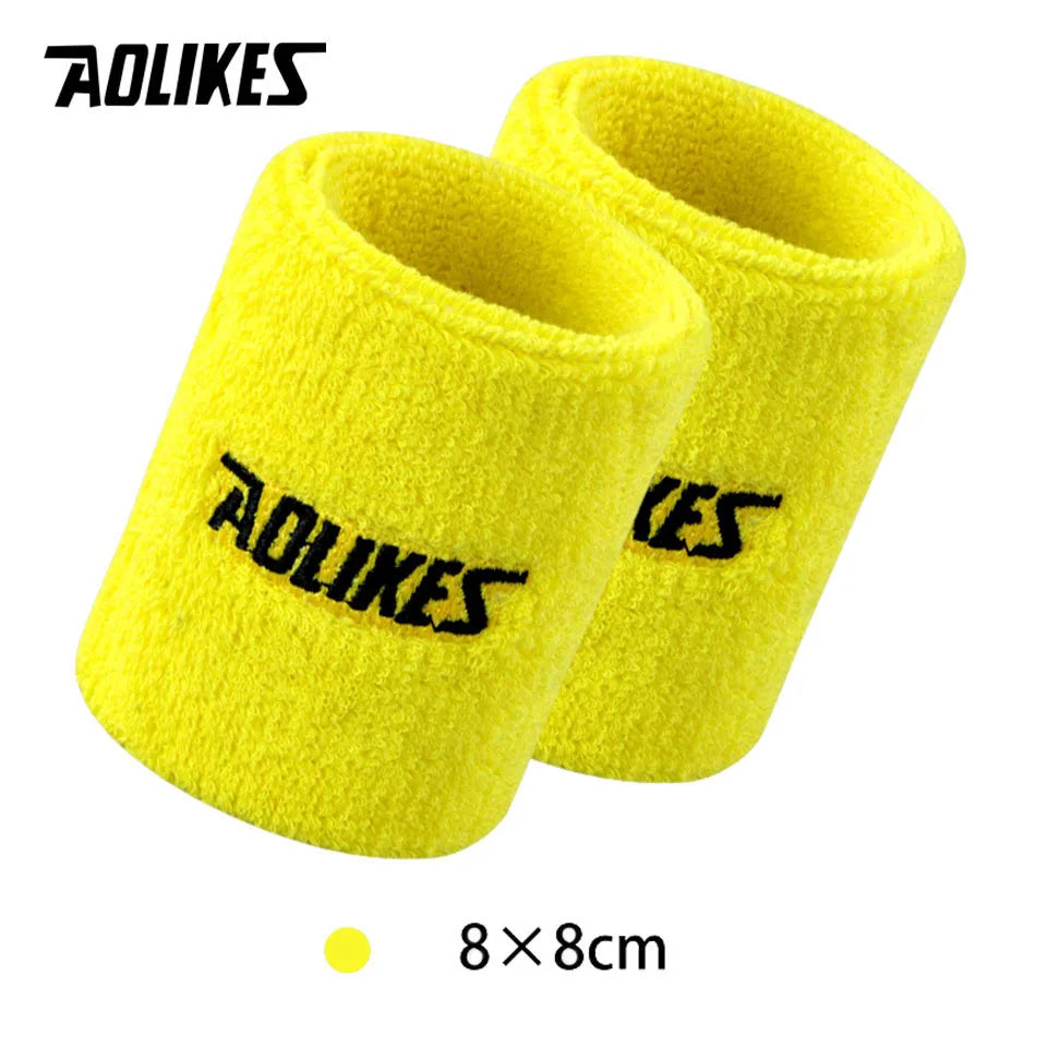 A pair of bright yellow, fuzzy wristbands for sport or activewear.