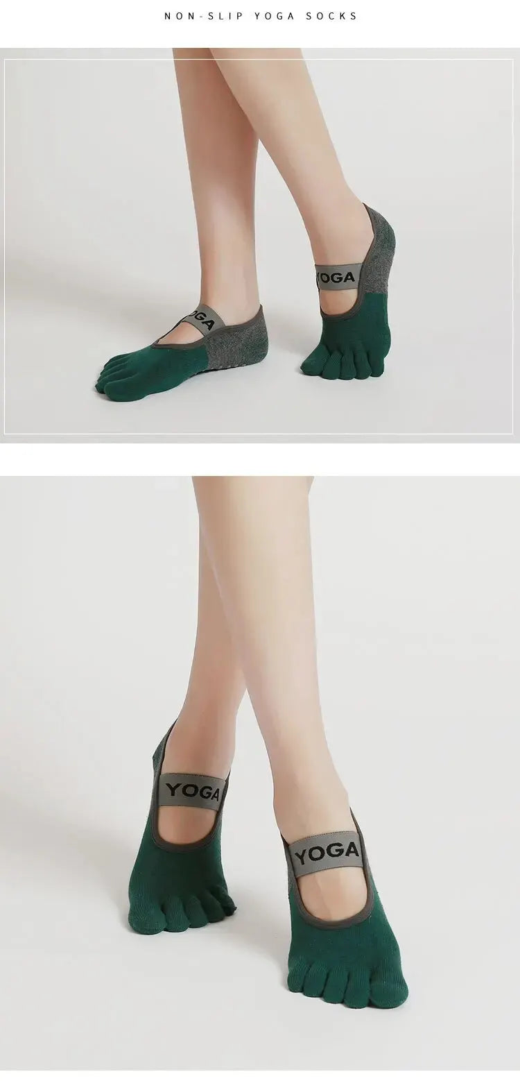 A pair of dark green silicone yoga socks with a gray accent, shown on a person's feet.