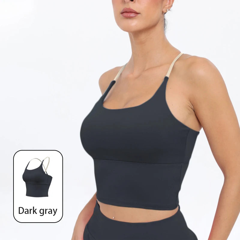 A model wearing a dark gray summer strappy yoga sports bra with built-in padding.
