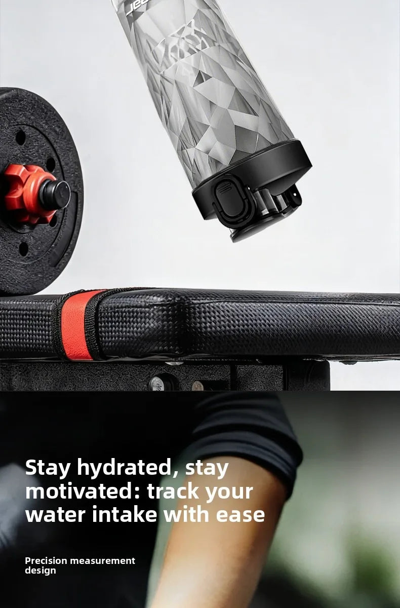 A close-up of a clear portable electric shaker bottle being shaken, with a black and red accessory visible.