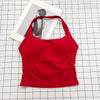 A bright red seamless sports camisole top laid on a white grid background with a photo in the background.