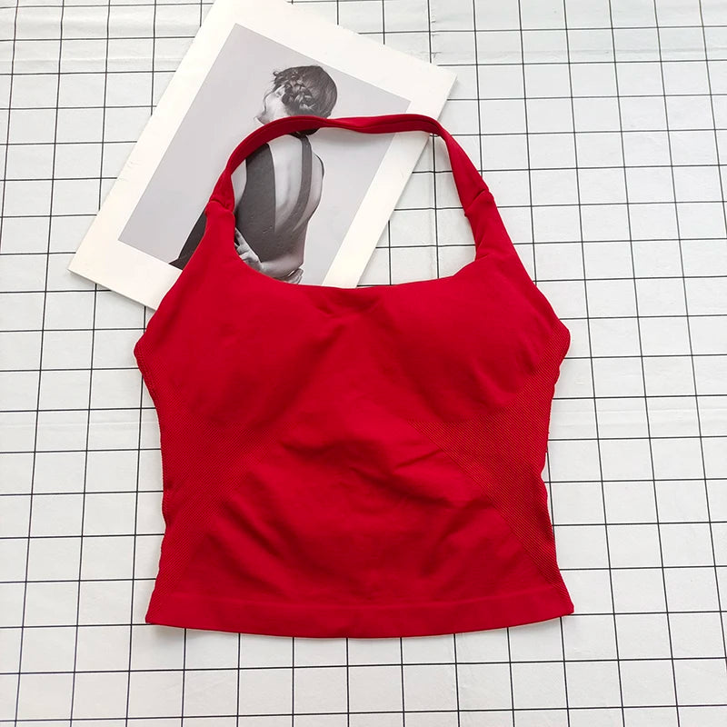 A bright red seamless sports camisole top laid on a white grid background with a photo in the background.