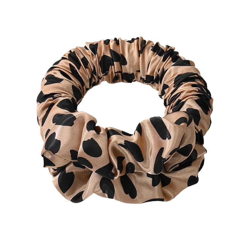 A beige and black animal print heatless curling rod headband made of gathered fabric.