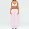 A woman wearing a pink women's premium fitness tracksuit top and matching pants.