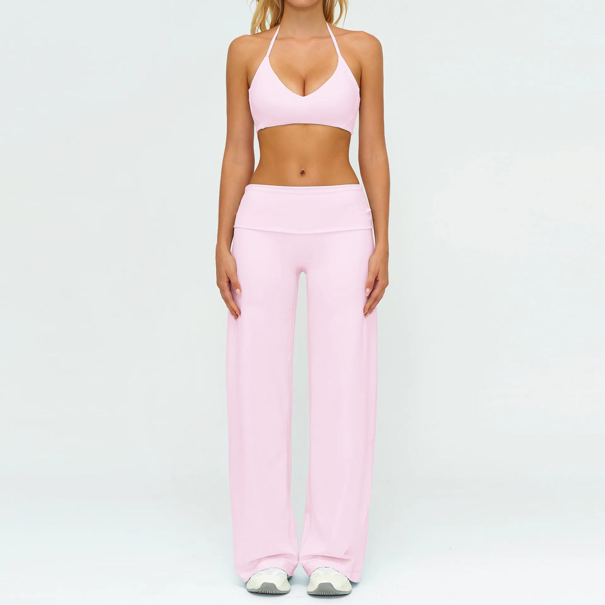 A woman wearing a pink women's premium fitness tracksuit top and matching pants.