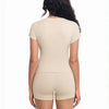 A woman wearing a beige two-piece workout set top and shorts from the back.