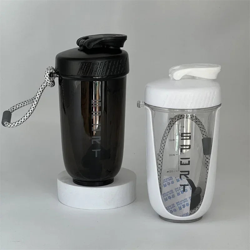 A black blender shaker bottle with a silver clip is shown next to a white version.