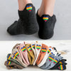 A stack of colorful embroidered ankle socks in various shades of pink, yellow, green, and purple.