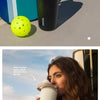 A woman holds an Owala insulated stainless steel travel mug outdoors.