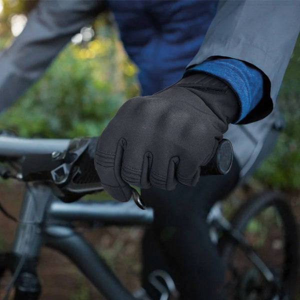 Nahaufnahme einer Person mit schwarzen Motorradhandschuhen, die ein Fahrrad fährt.