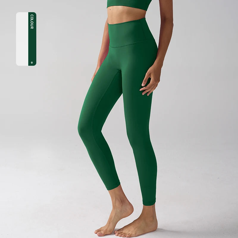 Un mannequin porte des leggings de performance vert foncé taille haute, vue en pied.