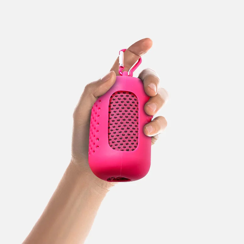A hand is holding a bright pink cooling towel with a mesh texture and a loop for drying.
