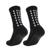 A pair of black multi-sport athletic grip socks with white chevron patterns.