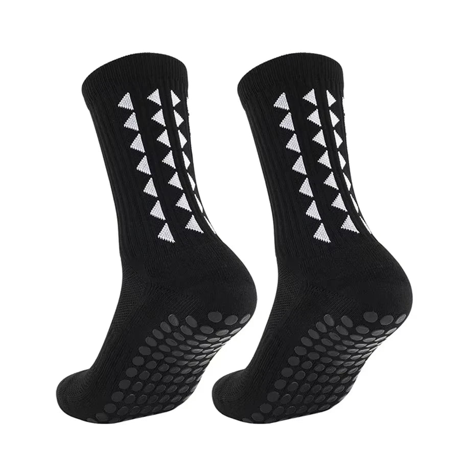 A pair of black multi-sport athletic grip socks with white chevron patterns.
