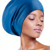 A close-up of a woman wearing a royal blue silicone swim cap for long hair.