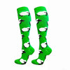 Pair of bright green compression elastic socks with a black and white cow print pattern
