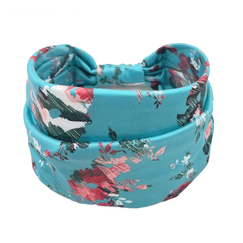 A teal floral butterfly headband with pink and green leaves