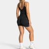 A woman models black leopard print seamless yoga shorts and white sneakers.