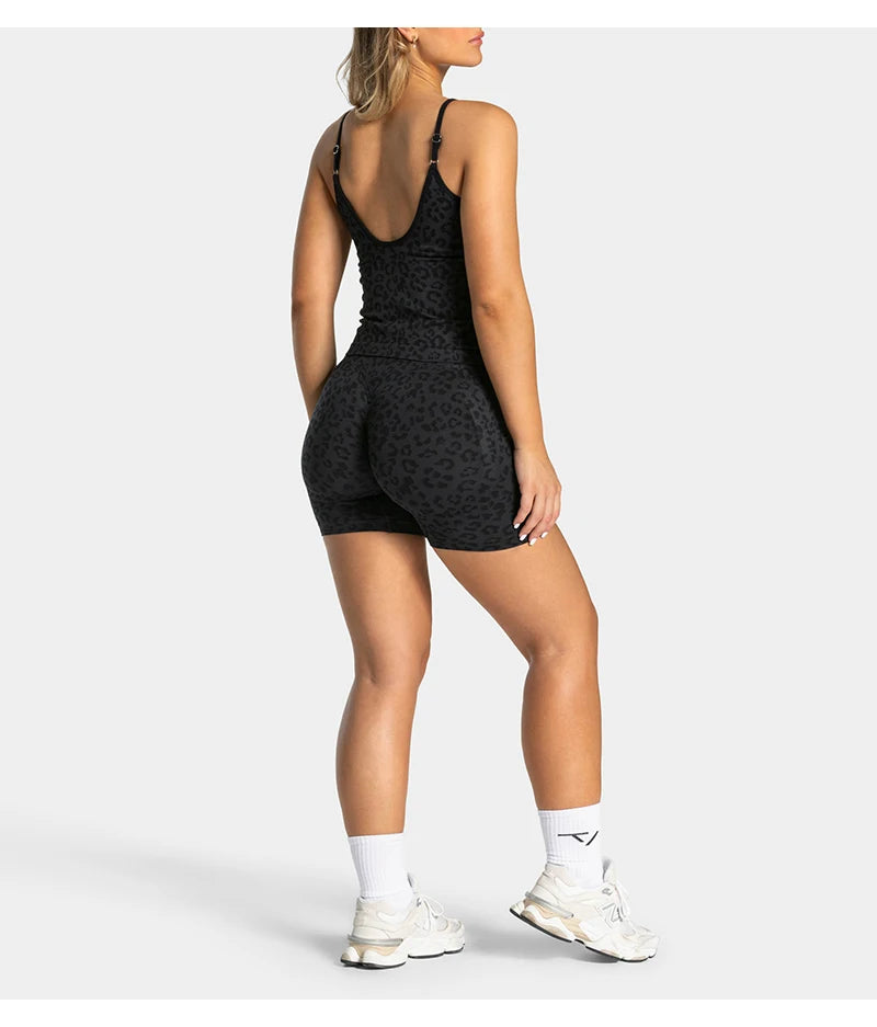 A woman models black leopard print seamless yoga shorts and white sneakers.