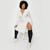 A woman models white patterned compression socks and a matching dress.