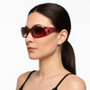 A close-up of a woman wearing red rhinestone Y2K cat eye sunglasses.