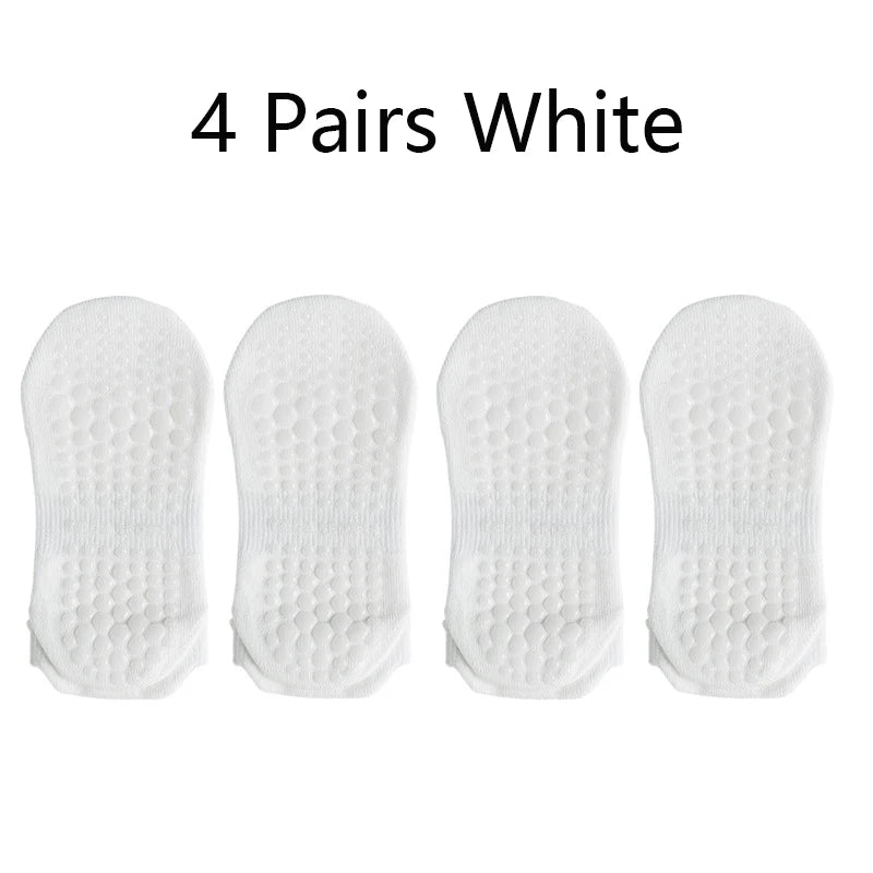 Four pairs of white non-slip yoga socks displayed side by side.