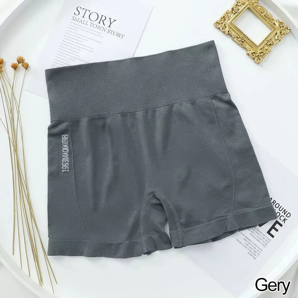 Shorts de fitness grises sin costuras para mujer, extendidos sobre una superficie blanca.